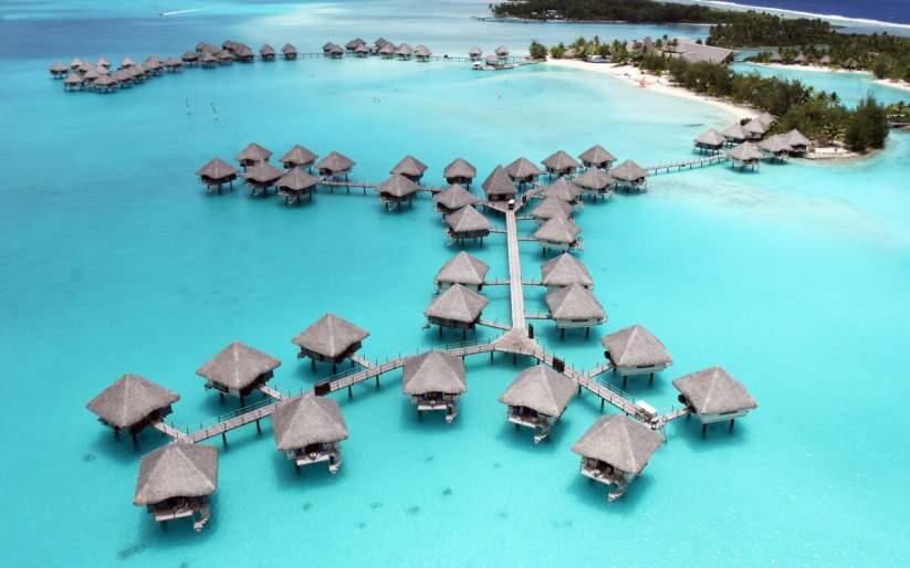 Overwater bungalows on the turquoise lagoon of Bora Bora, seen from above